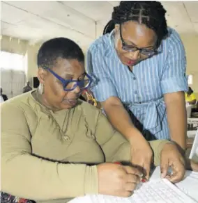  ?? (Photos: Joseph Wellington) ?? Erica Haughton (right), president designate of Kiwanis Club of New Kingston, helps Andrea Dallas go through her questionna­ire at a parenting seminar held at St Margaret’s Church Hall on Saturday, May 27.