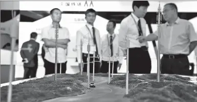  ?? LI XIN / XINHUA ?? Visitors watch a model of Hainan Wanning informatio­nalized expressway at the stand of China Tower at PT Expo China 2016, held inBeijing.