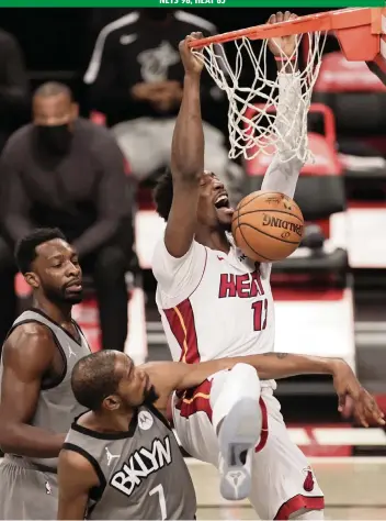  ?? ADAM HUNGER AP ?? The Heat’s Bam Adebayo dunks over Brooklyn forward Kevin Durant (7) and guard Kyrie Irving during the first half Monday. Adebayo had another strong offensive game with 26 points, 10 rebounds and five assists.