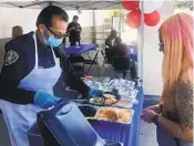  ?? DAVID HERNÁNDEZ U-T ?? El oficial Terry Hoskins prepara un plato de tacos afuera de un mercado de Northgate en El Cerrito.