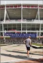  ?? BRYAN WOOLSTON / AP ?? Steven Taylor of Cincinnati walks past Great American Ball Park on Wednesday before the Reds’ exhibition game.