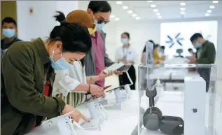  ?? SHA XIAOFENG / FOR CHINA DAILY ?? Shoppers browse electronic products at a duty-free shop in Hainan province.