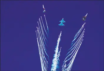  ?? Jon Gambrell The Associated Press ?? The Russian Knights perform a stunt Sunday after releasing chaff at the Dubai Air Show in Dubai, United Arab Emirates. The biennial Dubai Air Show opened Sunday as commercial aviation tries to shake off the coronaviru­s pandemic.