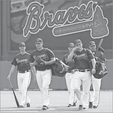  ??  ?? Atlanta Braves pitchers and catchers walk across the field at baseball spring training in Kissimmee, Fla., Wednesday, Feb. 14, 2018. (Curtis Compton/Atlanta Journal-Constituti­on via AP)