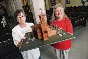  ?? Arnold Gold/Hearst Connecticu­t Media ?? History Committee members Nancy Staniewicz, left, and Sue Carlson hold a model of the original Christ Church inside the Church of the Holy Spirit in West Haven on May 24. Christ Church was renamed Church of the Holy Spirit after a merger. The wood for the model came from the original church.