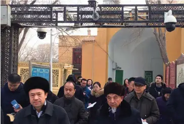  ??  ?? Surveillés. Imams et membres du gouverneme­nt sont filmés à la sortie de la mosquée Id Kah, la plus grande mosquée de Chine, à Kashgar (Xinjiang).