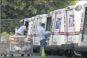  ?? RICHARD VOGEL— THE ASSOCIATED PRESS FILE ?? On Aug. 20, postal workers load their mail delivery vehicles at the Panorama city post office in Los Angeles.