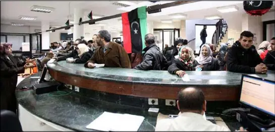 ??  ?? زبائن ينتظرون دورهم لانجاز معاملاتهم في مصرف في العاصمة الليبية طرابلس
