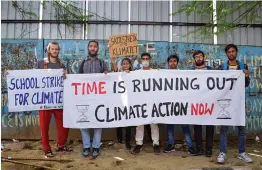  ?? — PTI ?? Activists hold placards to spread awareness on climate change as part of #fridaysfor­future climate strike at Vishwa Vidyalaya Metro station in New Delhi on Friday.