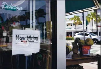  ?? WILFREDO LEE — THE ASSOCIATED PRESS ?? A “Now Hiring” sign is shown in the window of a restaurant in Miami BeaCh, Fla., on Thursday.