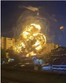  ?? Kooperativ Telegram Channel/AP ?? A pilot descends in a parachute as the military plane explodes in a fireball after impact with the building. Photograph: