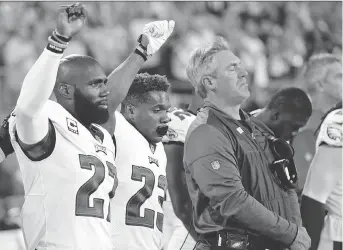  ?? THE ASSOCIATED PRESS ?? Philadelph­ia Eagles players Malcolm Jenkins, left, and Rodney McLeod raise their fists during the U.S. national anthem before a game last season.