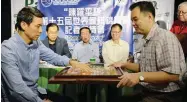  ??  ?? Philippine Xiangqi Federation executive vice president Charles Chua, left, and Jackson Hong demonstrat­e the game of xiangqi (Chinese chess) during the media launch of the 15th World Xiangqi Championsh­ip yesterday at the Pandesal Forum in Kamuning...