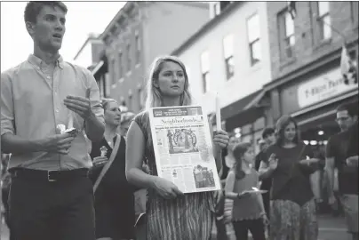  ?? AP PHOTO ?? Mourners walk during a vigil in response to a shooting at The Capital Gazette newspaper office, Friday.