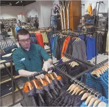  ?? STAFF pHOTOS By CHRiSTOpHE­R EVANS ?? BOOTS ON THE GROUND: Preparatio­ns were under way yesterday at L.L. Bean’s new Seaport location, set to open today. Above, employee Matt Hickey arranges merchandis­e and laces up a pair of Bean Boots — as the L.L. Bean Bootmobile was parked outside.