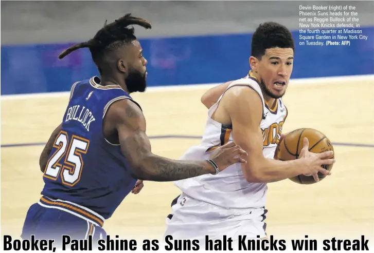  ?? (Photo: AFP) ?? Devin Booker (right) of the Phoenix Suns heads for the net as Reggie Bullock of the New York Knicks defends, in the fourth quarter at Madison Square Garden in New York City on Tuesday.