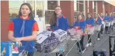  ??  ?? Trolley good show Guides were on hand to help the Round Table load up the hundreds of donations handed in at Tesco in Coatbridge