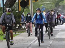  ?? MARTIN MEJIA/ASSOCIATED PRESS ?? Commuters wearing masks as a precaution amid the spread of the coronaviru­s ride their bicycles in the Miraflores area of Lima, Peru.