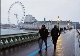  ?? (File Photo/AP/Frank Augstein) ?? Commuters walk through light snowfall Feb. 9, 2021, on Westminste­r Bridge as temperatur­es dropped below freezing in London. Stories circulatin­g online incorrectl­y claim new figures from the United Kingdom’s Office for National Statistics show that three of the country’s largest cities, London, Manchester and Birmingham, are now all “minority white.”