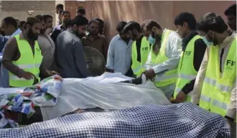  ?? M.I. HAQ/THE ASSOCIATED PRESS ?? The bodies of 20 people killed at a shrine they attended to seek spiritual guidance are laid out at a local morgue.