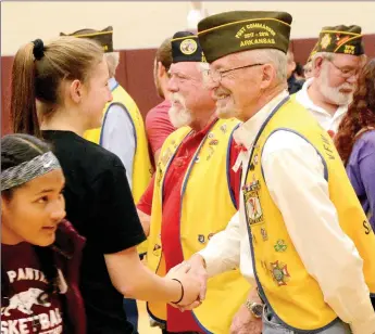  ?? Janelle Jessen/Herald-Leader ?? Students shook hands with VFW Post 1674 member Bennie Gallant, right, and Ron Evans, center, after the community Veterans Day program at the Siloam Springs High School on Monday. Students were invited down to greet veterans after the program and many crowded around to give veterans hugs and handshakes.