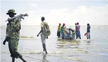  ??  ?? A FISHY TALE: A Turkana man lays out flattened fish for drying in the sun near Lowarengak on the western shores of Lake Turkana, northern Kenya.