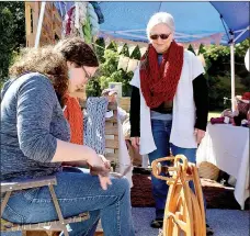  ?? File photo/Siloam Sunday ?? Visitors got a chance to try spinning wool into yarn at a vendor booth during the 2015 Homegrown Festival. This year’s festival, to be held Oct. 8 in downtown Siloam Springs, will include craft vendors, food trucks, live music and lots of fall-themed...