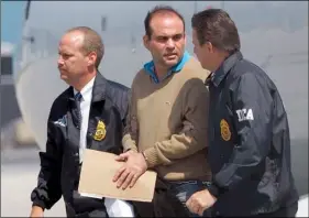  ?? AP Photo/Alan Diaz ?? In this 2008 file photo, Colombian paramilita­ry warlord Salvatore Mancuso is escorted by U.S. DEA agents upon his arrival to Opa-locka, Florida.