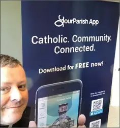  ??  ?? Fr. John Carroll pictured with the promotiona­l banner for the app.