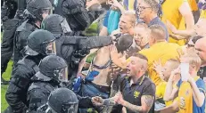  ?? FOTO: DPA ?? Angriff der Chaoten: Brauchschw­eiger Fans stürmten nach dem Abpfiff das Spielfeld – die Polizei hatte die Lage schnell unter Kontrolle.