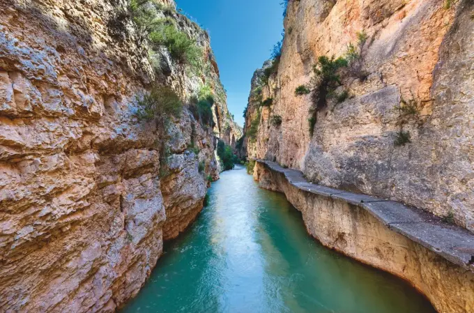  ?? ?? El río Mundo sale con fuerza del embalse de Camarillas y discurre encajado entre los paredones de roca del cañón de los Almadenes. Abajo, pinturas rupestres del Abrigo Grande de Minateda, la Capilla Sixtina del arte rupestre levantino, que forman parte del Patrimonio de la Humanidad de la Unesco. Merece la pena destacar la destreza con la que los artistas realizaron las figuras sobre la pared, para las que utilizaron óxido de hierro como pigmento principal.