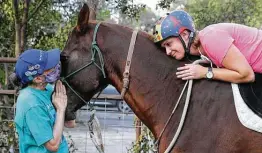  ?? Kin Man Hui / Staff photograph­er ?? Julia “Rabbitt” Mclernon, left, and Jenna Davis offer affection to Horsepuppy.