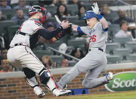  ?? John Bazemore Associated Press ?? CHASE UTLEY of the Dodgers is tagged out at home by Tyler Flowers of the Braves to end the eighth inning. Utley was attempting to score from second on a Cody Bellinger single. Bellinger earlier homered in the Dodgers’ ninth win in a row and 40th in 46...