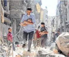 ?? Foto: Ameer Alhalbi, afp ?? Zwei Männer, die Babys in Sicherheit bringen, bahnen sich ihren Weg durch die Trümmer ihrer Heimatstad­t Aleppo.