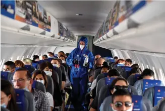  ?? (Prime Minister’s Office) (Yossi Zeliger/Flash90) ?? LEFT: MONITORING the latest corona figures in his office.
A FLIGHT attendant wearing full protective gear walks the aisle during an Israir flight between Tel Aviv and Eilat on May 13.