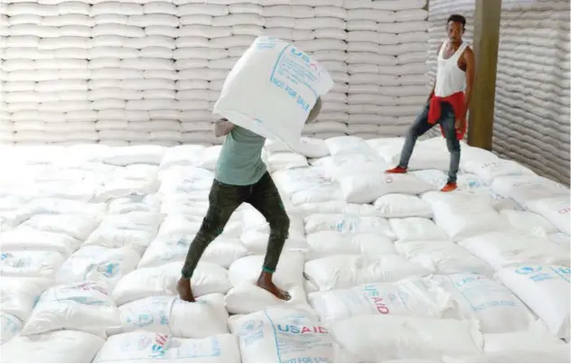  ?? File/reuters ?? Labourers offload bags of grains in Adama town, Ethiopia.