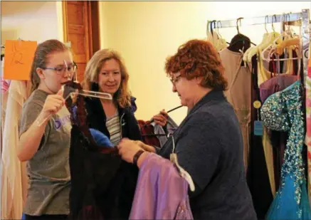  ?? CHARLES PRITCHARD - ONEIDA DAILY DISPATCH ?? Alannah Henry, 17, and her mother Julie Titus of Oneida, middle, look through a number of dresses at the Prom Dress Giveaway with volunteer Becky Ewen on Feb. 102018