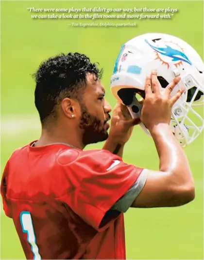  ?? WILFREDO LEE/AP ?? Tua Tagovailoa takes off his helmet Tuesday between drills during a mandatory minicamp at the Dolphins training camp in Davie.