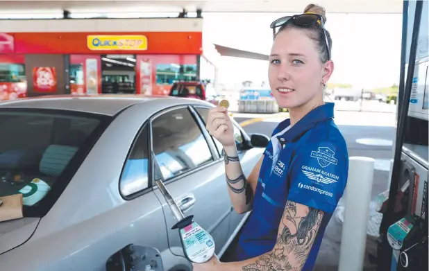  ?? Picture: STEWART McLEAN ?? BARGAIN PETROL: Kristen Pearce from Gordonvale fills up her car for a dollar a litre.