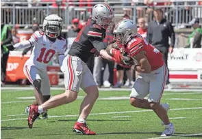  ?? JASON MOWRY/COLUMBUS DISPATCH ?? Ohio State quarterbac­k Will Howard hands the ball off to running back Treveyon Henderson during Saturday's spring game.