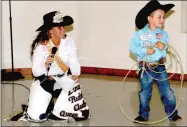  ?? MARK HUMPHREY ENTERPRISE-LEADER ?? Colton Workman, 4, walks away grinning from an interview with 2014 Lincoln rodeo queen Courtney Bilderback during the Little Mister Contest. When he lassoed the queen after the contest and she graciously offered a kiss on the cheek, Colton immediatel­y...
