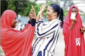  ?? SUNDAY ALAMBA / ASSOCIATED PRESS ?? Bring Back Our Girls campaigner­s celebrate the release of the kidnapped Chibok schoolgirl­s at the unity fountain in Abuja, Nigeria, on Sunday. Five Boko Haram commanders were released in exchange for the 82 girls.