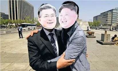  ?? FOTO: AFP ?? Dafür oder dagegen? Diese beiden Aktivisten in Seoul scheinen eine Annäherung zwischen Nordkoreas Staatschef Kim Jong Un (r.) und Südkoreas Präsidente­n Moon Jae In zu favorisier­en.