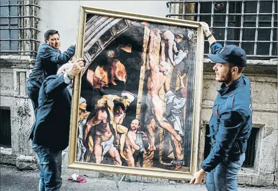  ?? FABIO FRUSTACI / EFE ?? La policía retira la obra de arte urbano El incendio del Nazareno –con figuras de políticos–, colgada ayer cerca de la sede del PD