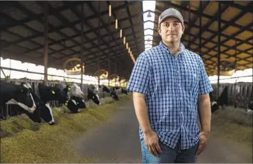  ??  ?? DEVIN GIOLETTI, shown in a barn at his family’s dairy, and his brother are pondering whether to hand off the farm. “We have to think about whether we want to pass debt on to the next generation,” he says.