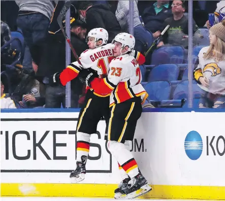  ?? KEVIN HOFFMAN/GETTY IMAGES ?? Flames forwards Johnny Gaudreau and Sean Monahan celebrate Gaudreau’s overtime winner against the Buffalo Sabres at the KeyBank Center Tuesday night. The Flames are now 2-0-1 in their last three games.