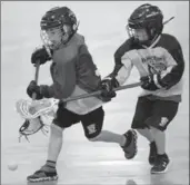  ??  ?? From top: Hamilton minor tyke (seven- and eight-year-old) lacrosse players in action. Bo Henhawk, 22, makes traditiona­l wooden lacrosse sticks. Members of the Six Nations Arrows wave to their cheering fans as they ride through town after the lacrosse...