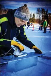  ?? FOTO: CATA PORTIN ?? Jussi Katajisto lånar ett■ strykjärn av medtävlare­n Riitta Matikainen i utbyte mot att han servar hennes verktyg. Med strykjärne­t, en aluminiump­latta och ett vattenpass ser han till att får raka ytor på isblock som ska fogas ihop med varandra.