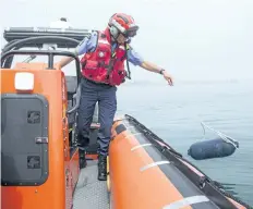  ?? HARLEY DAVIDSON/STANDARD STAFF ?? Brad Lavantis of Port Weller Search and Rescue tosses a buoy into the water as a demonstrat­ion of how hard it is to find objects or people in the water.