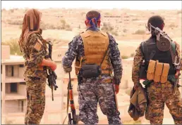  ??  ?? Fighters from the Syrian Democratic Forces look toward the northern town of Tabqa, Syria, on April 30.